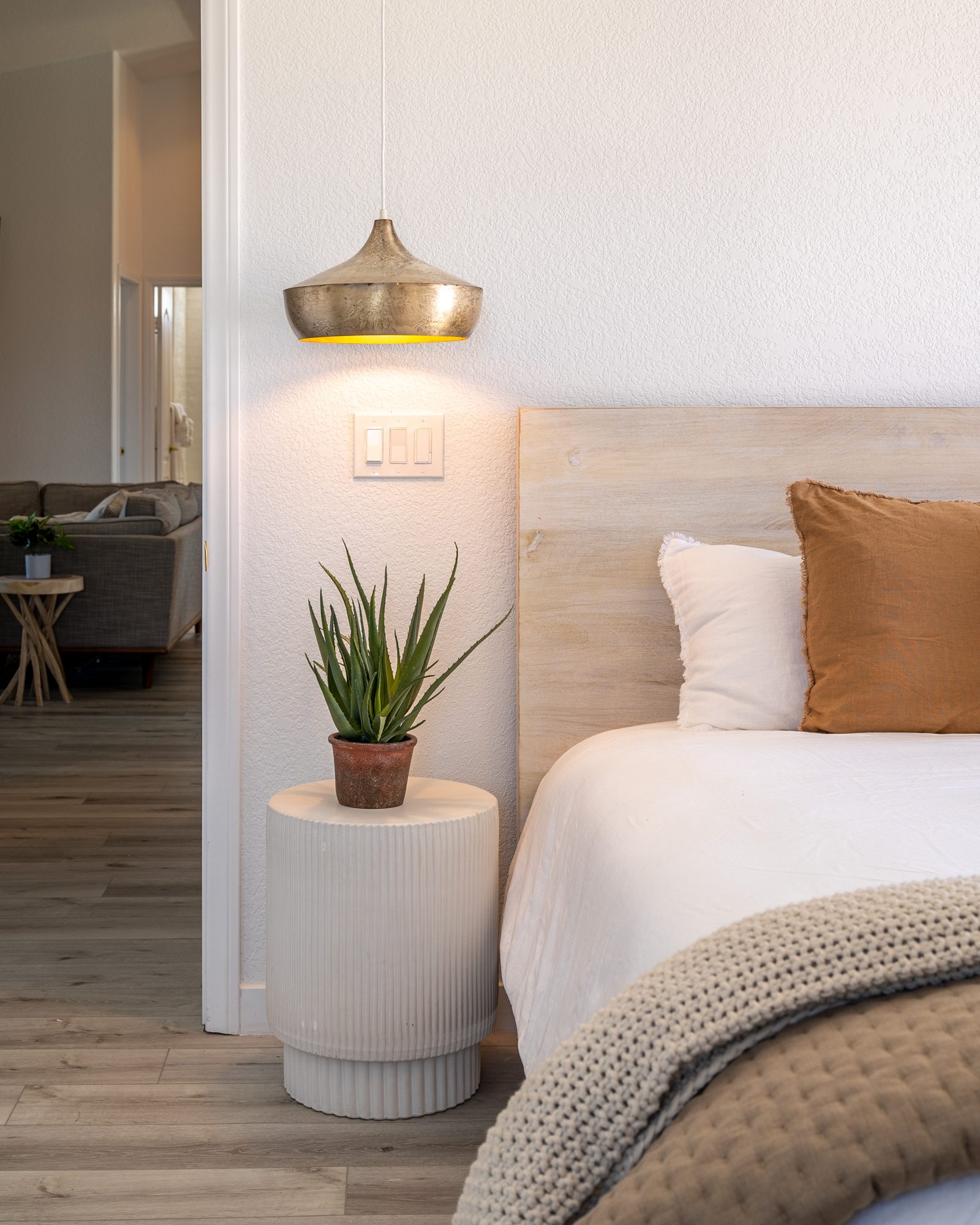 Guest bedroom with wood headboard and brass pendant in a coastal Orange County home by Naomi Satya Interiors