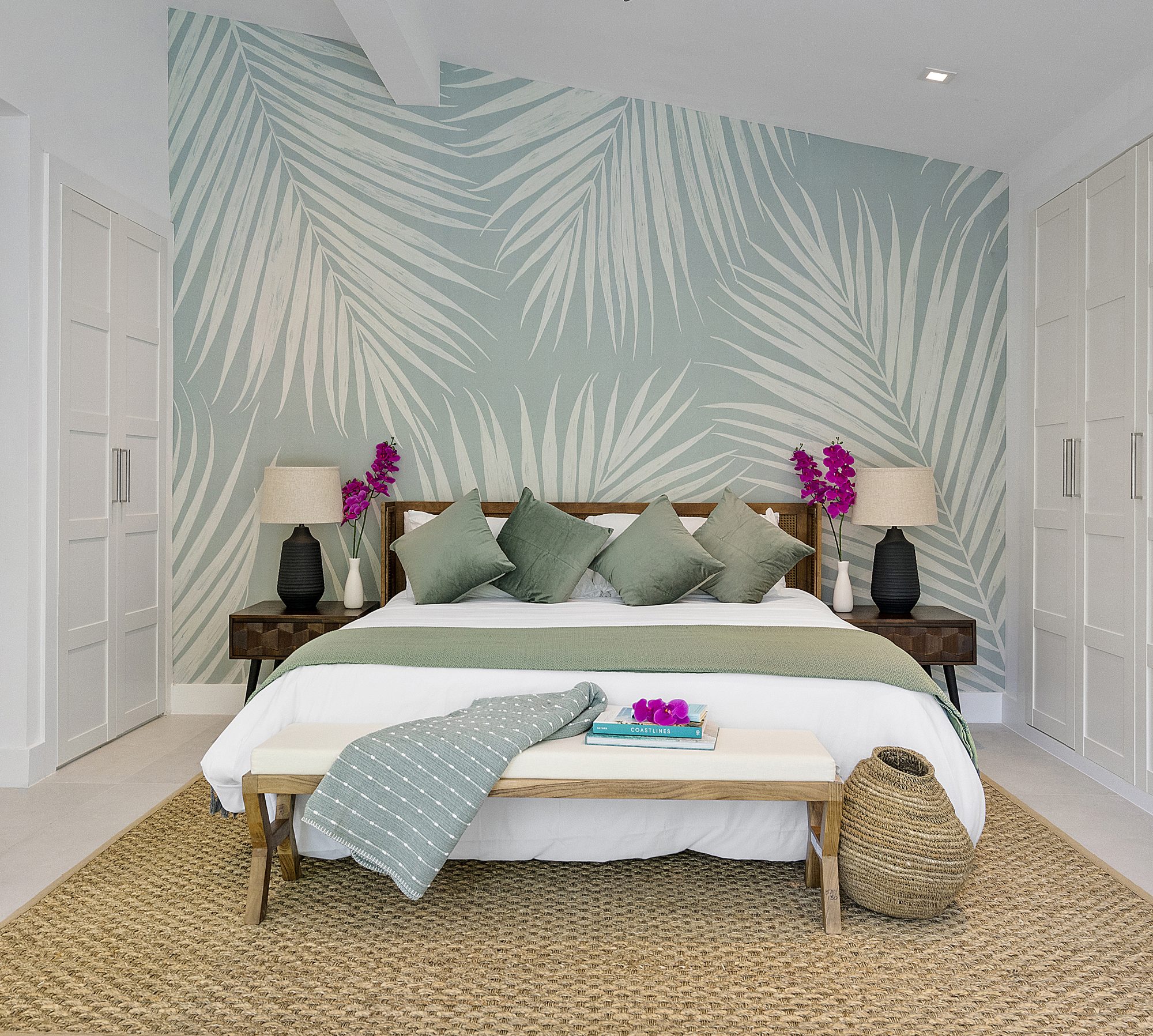 Bedroom with palm leaf mural in a Miami home designed by Naomi Satya Interiors